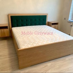 Meble Grzywacz - Drewniane łóżko z zielonym wezgłowiem i szafkami nocnymi, minimalistyczny design, jasna podłoga, widok z boku.