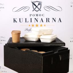 K&M INVEST Sp. z o.o. - Styropianowy pojemnik termiczny z trzema białymi pojemnikami na jedzenie i dwoma brązowymi kubkami z pokrywkami na czarnej pokrywie, na tle białej ściany z powtarzającym się logo 'Pomoc Kulinarna'.