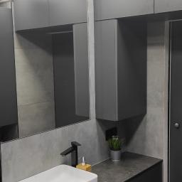 Ernest Nowak Usługi remontowo-budowlane - Nowoczesna łazienka w odcieniach szarości z białą, prostokątną umywalką, czarną armaturą, lustrem z podświetleniem LED i dekoracyjną rośliną w metalowej doniczce.