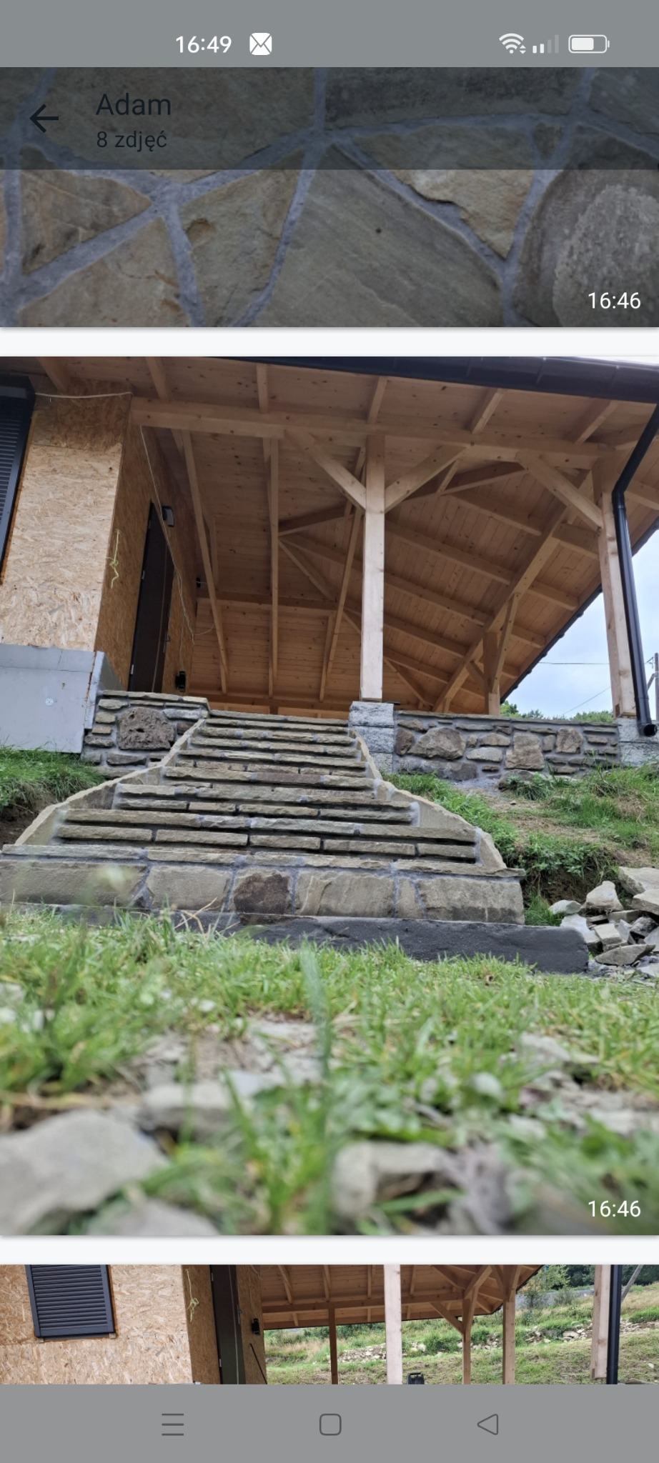 Kamienne schody prowadzące do drewnianego domu w trakcie budowy, widok z dołu, z bliska na trawnik, surowe wykończenie elewacji z płyt OSB.