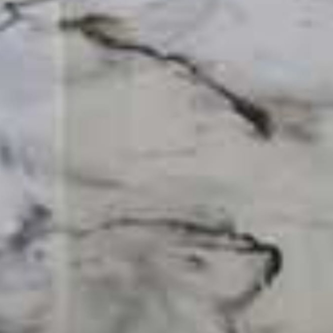 Szara, abstrakcyjna powierzchnia z ciemnymi smugami, przypominająca marmur lub żywicę epoksydową. Niejednolita faktura z delikatnymi przejściami tonalnymi.