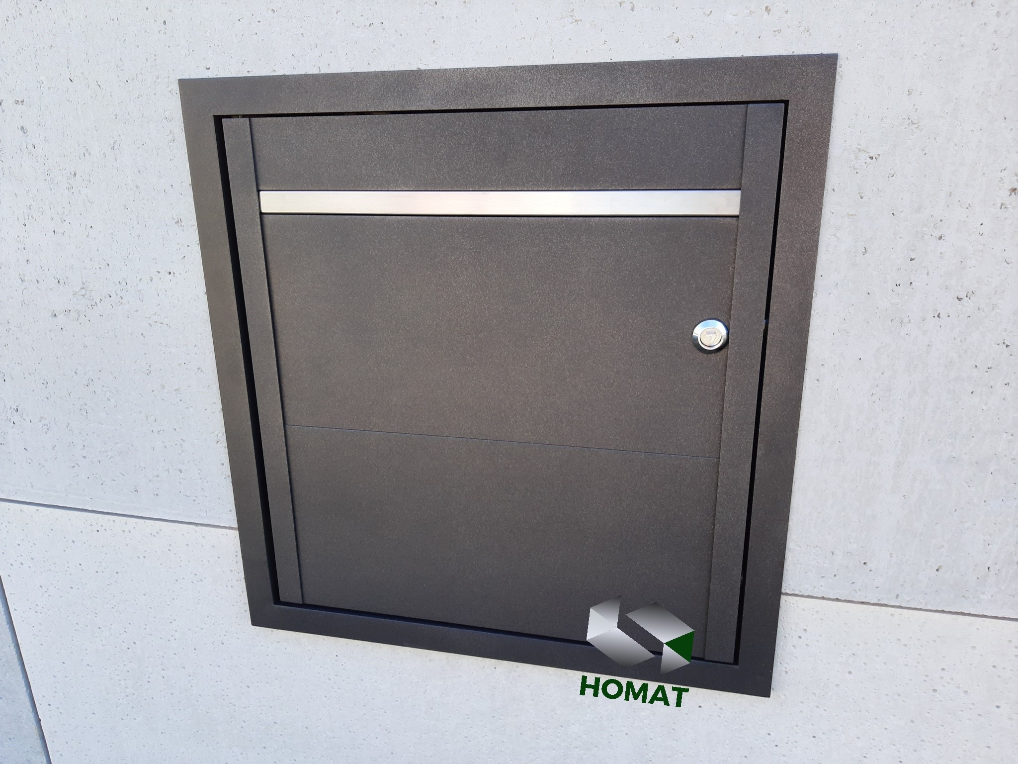 Metalowa klapa rewizyjna wbudowana w szarą ścianę, z poziomym, srebrnym akcentem i zamkiem.