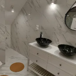 Wykończona łazienka na poddaszu z marmurowymi płytkami, dwiema czarnymi umywalkami nablatowymi, okrągłym lustrem w czarnej ramie i brązowym dywanikiem na podłodze.