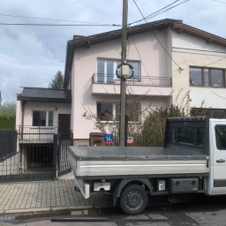 PHU Malbis Leszek Kaleta - Dom jednorodzinny po renowacji elewacji, z zaparkowanym samochodem dostawczym firmy budowlanej. Widoczne detale architektoniczne i świeża kolorystyka.