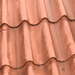 Hydrodynamiczny JAKUB SUROWANIEC - Czerwona dachówka ceramiczna z widocznymi śladami zabrudzeń i mchu. Na lewo widoczny fragment liny zabezpieczającej.