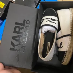 Espadryle Karl Lagerfeld w pudełku, widoczne logo na butach i na pudełku, buty leżą obok siebie w pudełku.