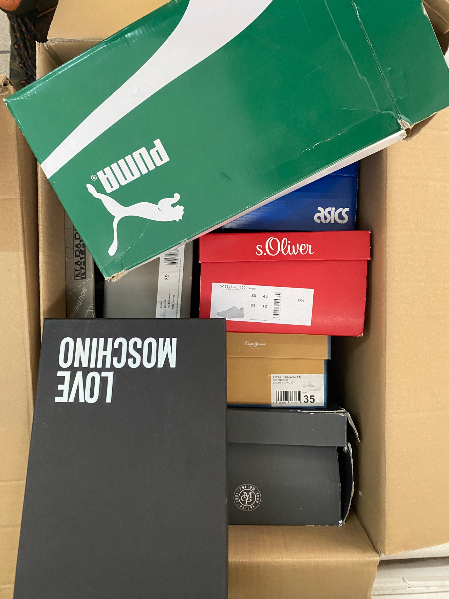 Karton wypełniony pudełkami po butach różnych marek, w tym Puma, Asics, s.Oliver, Pepe Jeans i Love Moschino.