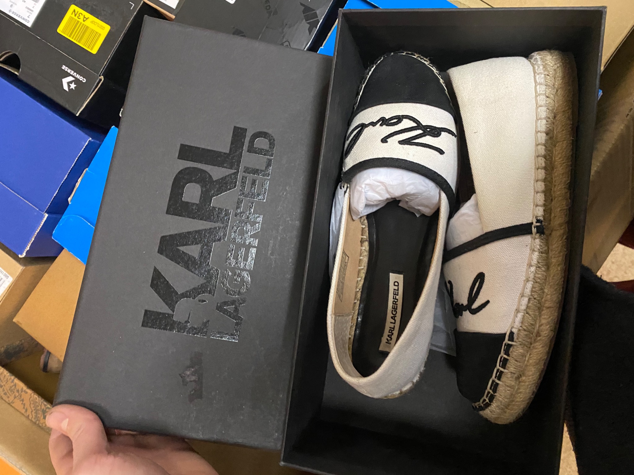 Espadryle Karl Lagerfeld w pudełku, widoczne logo na butach i na pudełku, buty leżą obok siebie w pudełku.