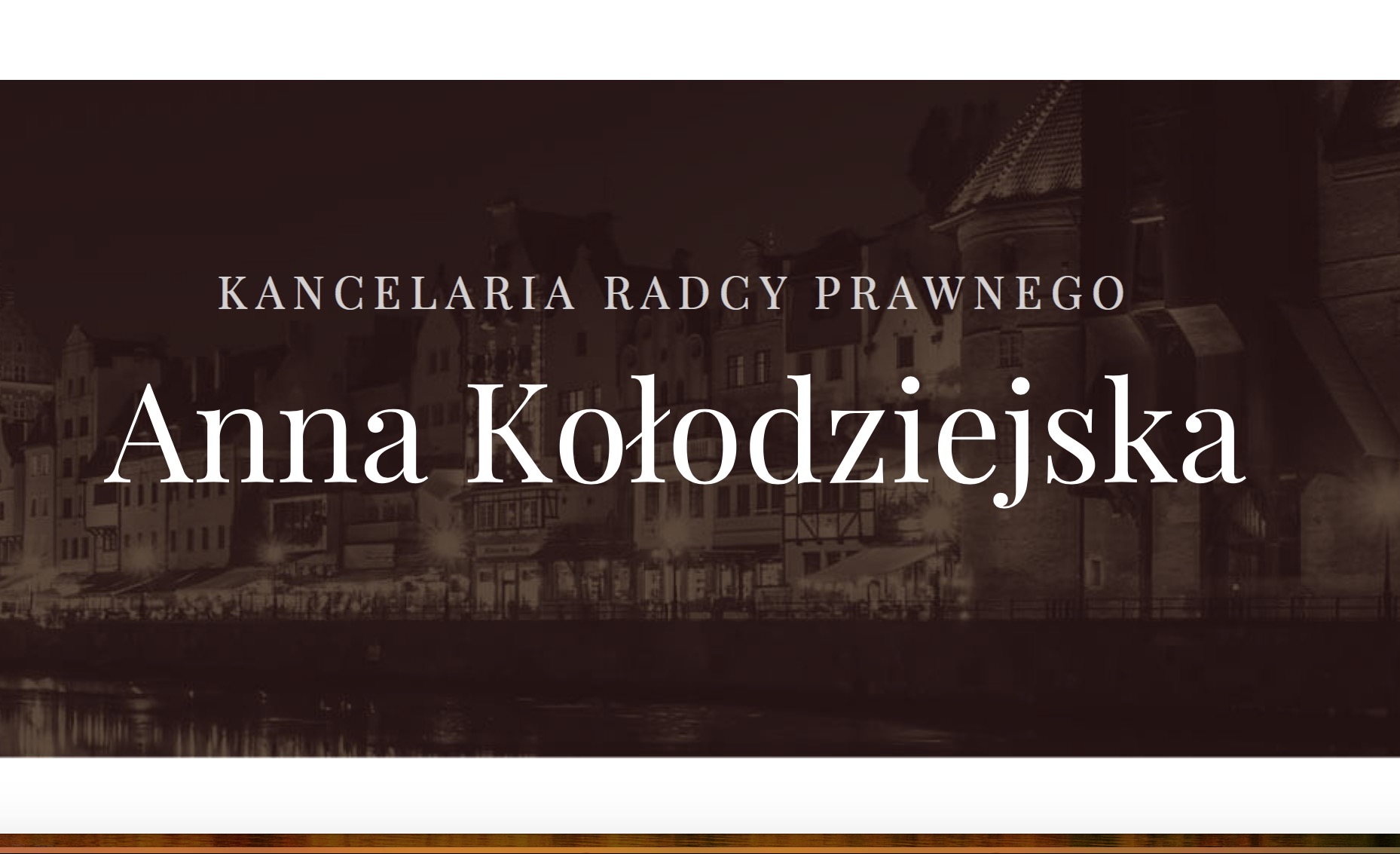 Eleganckie logo kancelarii prawnej Anny Kołodziejskiej na tle nocnego krajobrazu starego miasta.