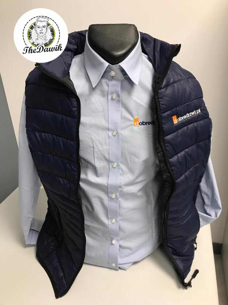 Niebieska koszula z długim rękawem i granatowa pikowana kamizelka z widocznym logo firmy 'dobredrzwi.pl' na manekinie.