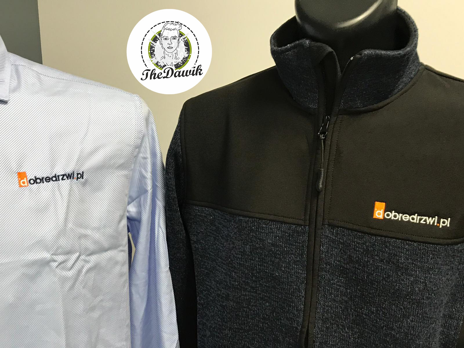 Koszulka w paski i czarna bluza z logo 'dobredrzwi.pl' wyhaftowanym na piersi, obok okrągła naklejka z logo 'The Dawik'.
