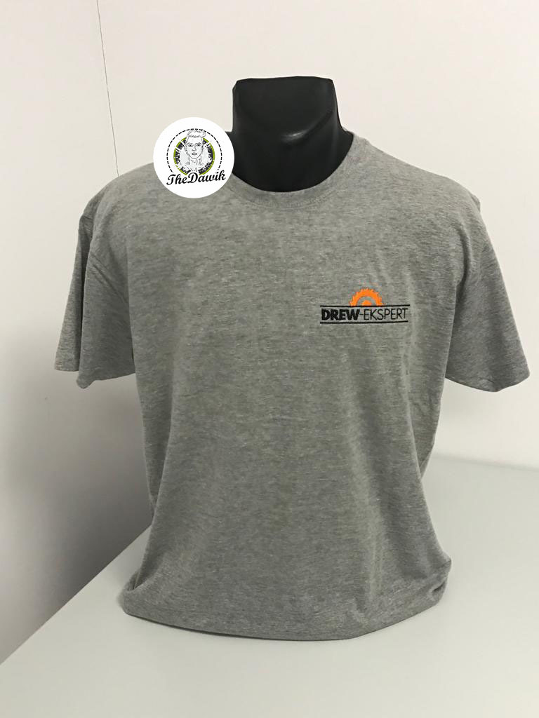Szara koszulka z krótkim rękawem, umieszczona na manekinie, z małym, pomarańczowo-czarnym logo 'DREW-EKSPERT' na lewej piersi.