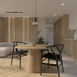 Jasne wnętrze mieszkania z drewnianymi akcentami: okrągły stół z czarnymi krzesłami, sofa w rogu i zabudowa kuchenna z piekarnikiem.