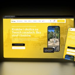 Koalas.Digital - Responsywna strona internetowa wypożyczalni hulajnóg na ekranie laptopa i smartfonie. Żółta kolorystyka, widok na Kraków, prosty proces rezerwacji. Prezentacja mobilnego przewodnika.