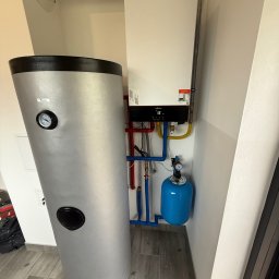 Lubas Serwis - Nowoczesna instalacja grzewcza: biały piec gazowy Viessmann, srebrny zasobnik wody i niebieskie naczynie przeponowe w jasnym pomieszczeniu.