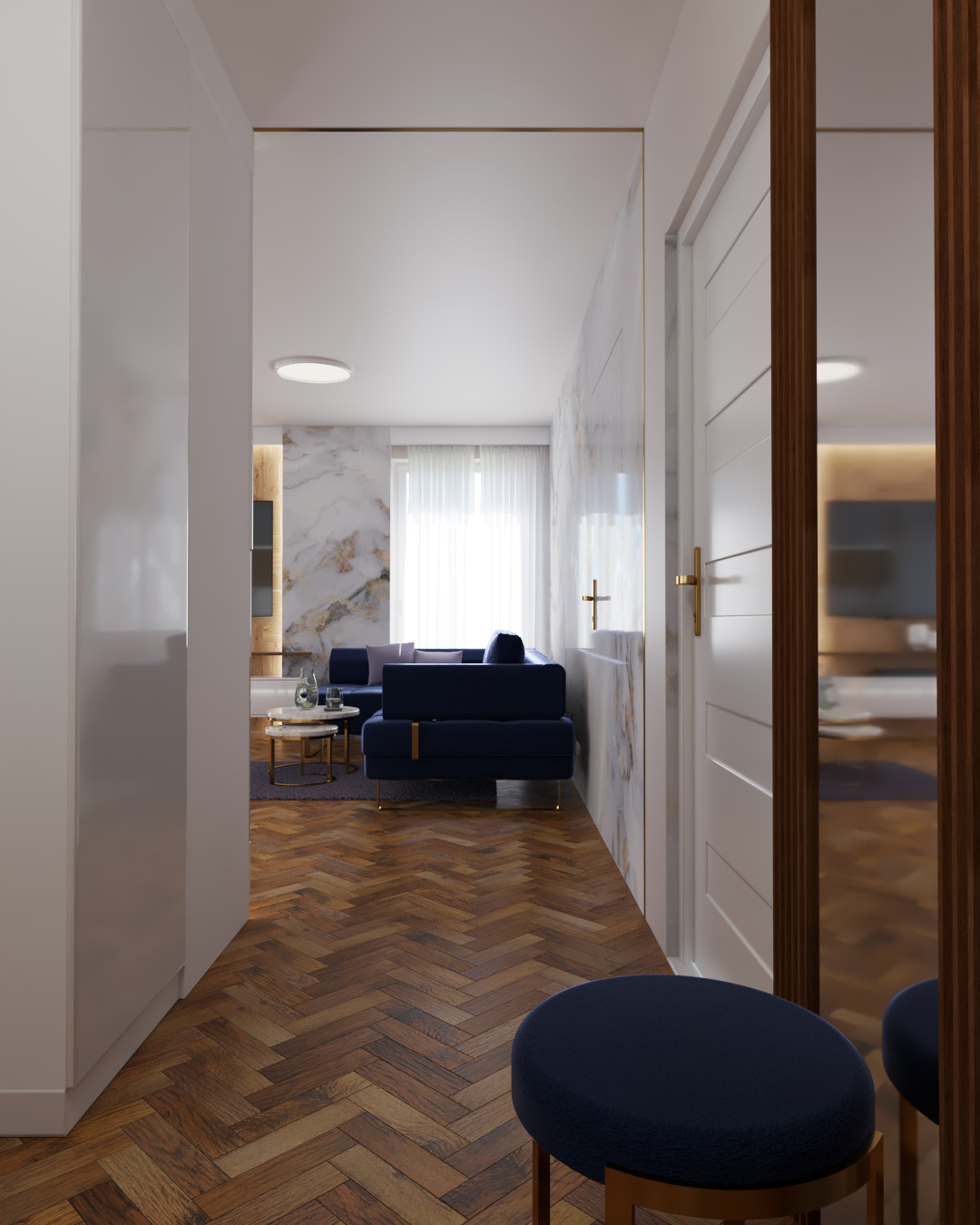 Wnętrze mieszkania z parkietem w jodełkę, granatową sofą i marmurową ścianą z delikatnym złotym akcentem, widoczne z perspektywy korytarza z białymi szafami i okrągłym siedziskiem.