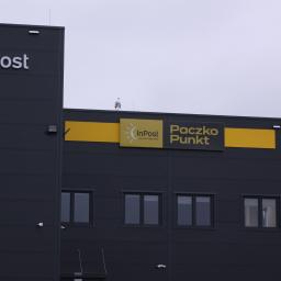 Concret Artur Zagrodnik - Budynek InPost Paczko Punkt z widocznymi oknami i logotypami, na zewnątrz szara, pochmurna pogoda.