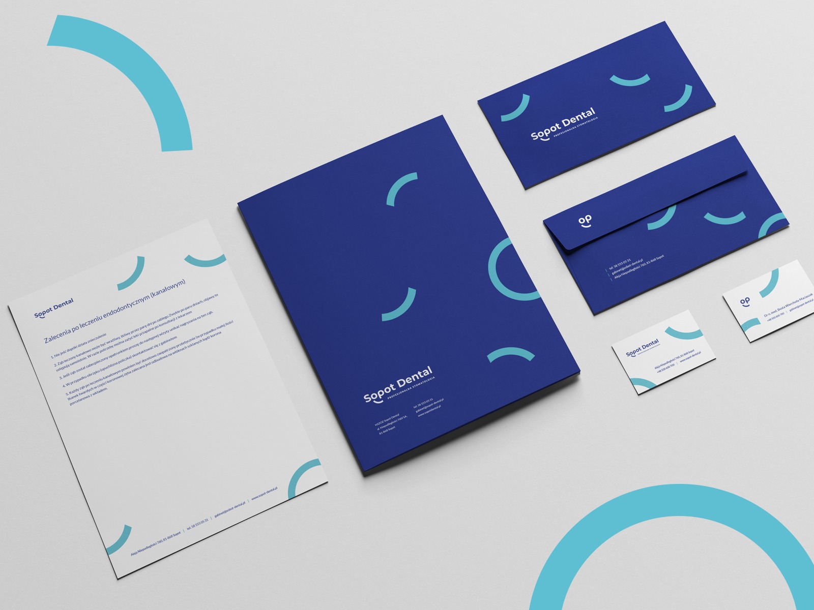 Zestaw materiałów firmowych Sopot Dental: wizytówki z logo OP, koperta, firmowy folder oraz ulotka z zaleceniami po leczeniu kanałowym, wszystko w kolorystyce granatowo-błękitnej z motywem...