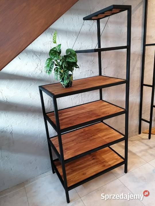 Regał z drewnianymi półkami i czarną metalową ramą, na górnej półce roślina doniczkowa, widoczne elementy schodów w tle.