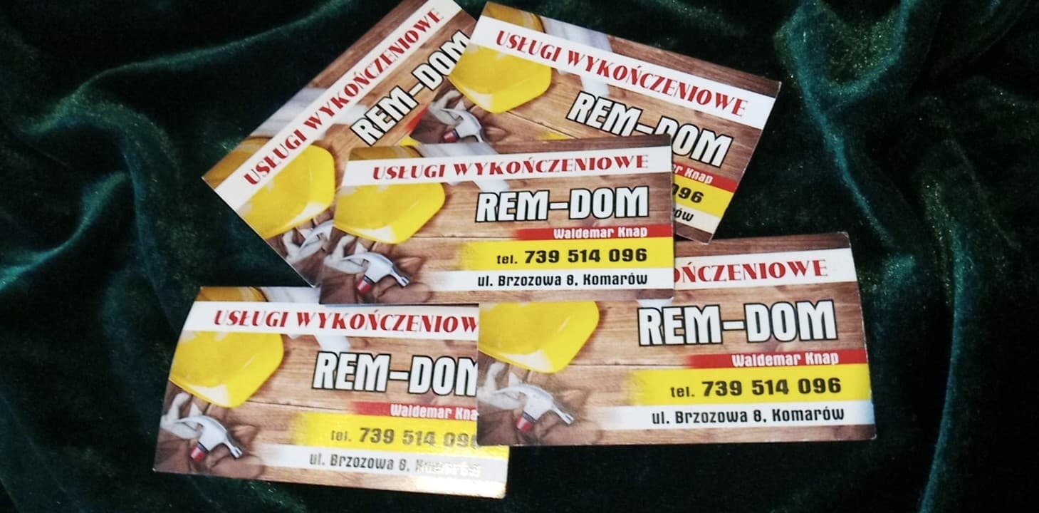 Wizytówki firmy Rem-Dom świadczącej usługi wykończeniowe, ułożone na ciemnozielonym, błyszczącym materiale. Na wizytówkach widnieje logo, nazwa firmy, dane kontaktowe oraz grafika przedstawiająca...
