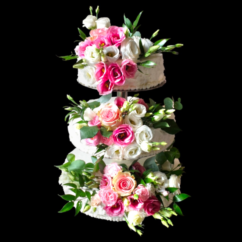 Trzypiętrowy tort weselny zdobiony świeżymi różowymi i białymi kwiatami, umieszczony na metalowym stojaku, na czarnym tle.