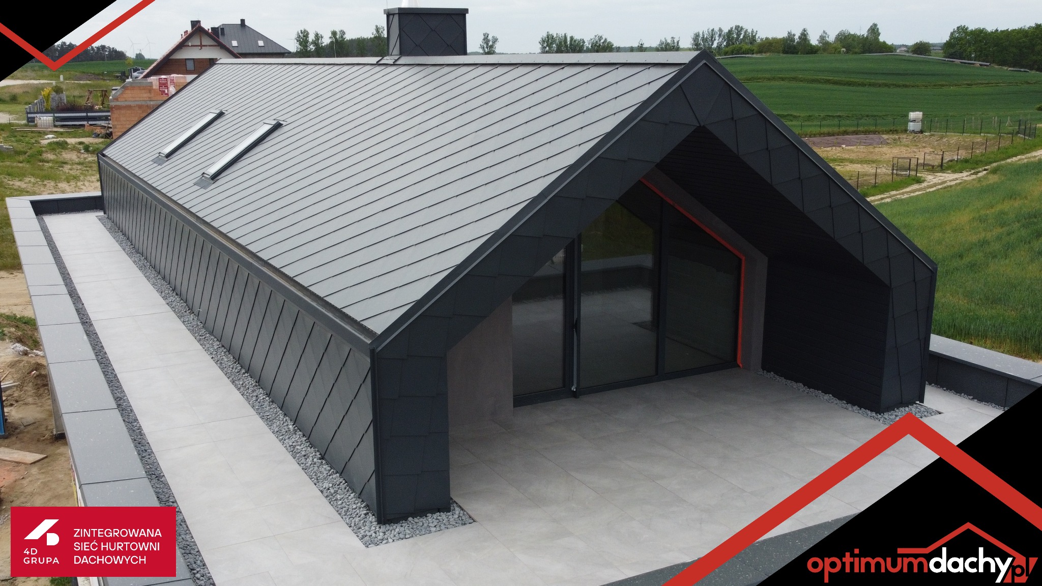 Nowoczesny dom z ciemnoszarą blachą na dachu i oknami dachowymi, widok z góry. Minimalistyczny design, płaska połać dachu i otoczenie z zielenią w tle.