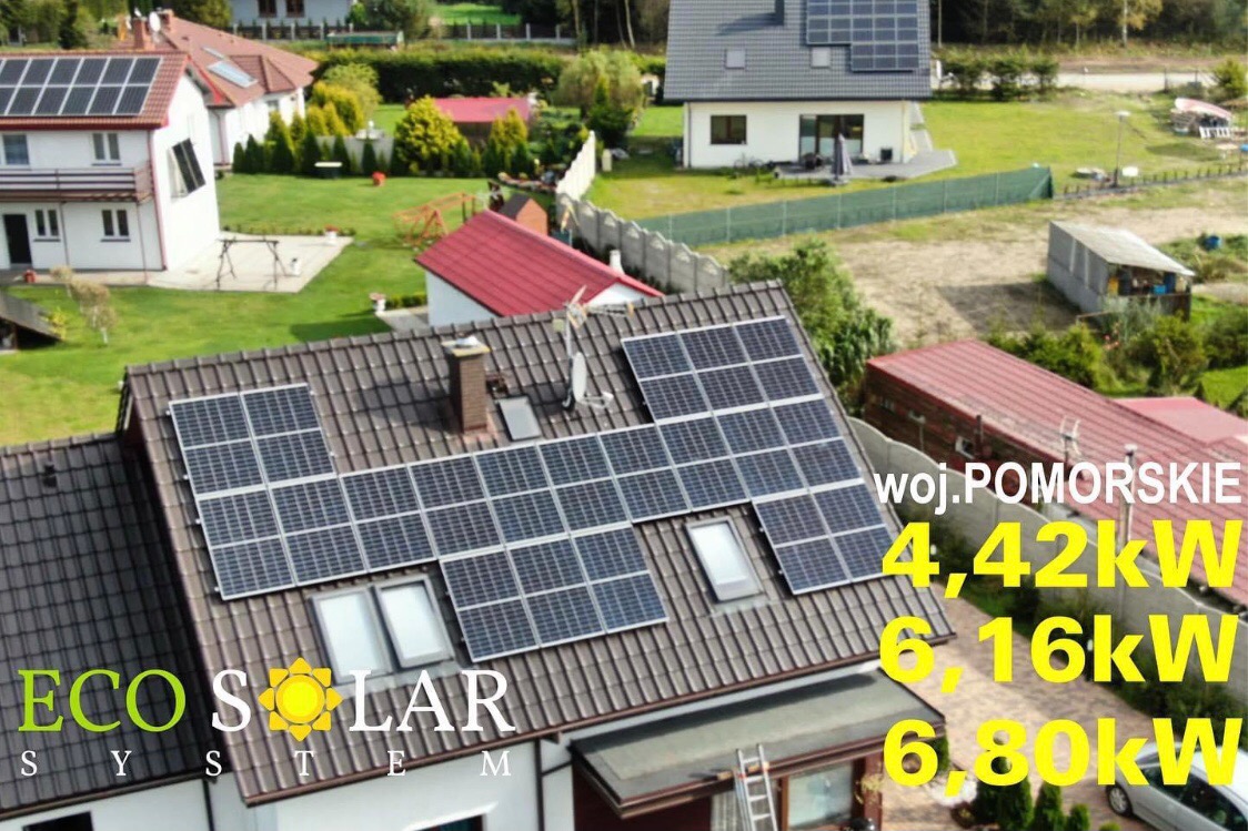 Widok z góry na brązowy dach domu z panelami słonecznymi zamontowanymi pomiędzy oknami dachowymi, z logo firmy i danymi o mocy instalacji nałożonymi na obraz, w tle inne domy i zieleń.