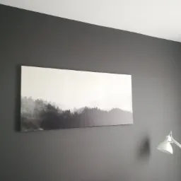 Ściana w odcieniach szarości z obrazem przedstawiającym mglisty las i lampką biurkową.