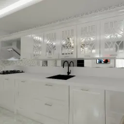 Biała kuchnia z frezowanymi frontami szafek wiszących, czarną armaturą i blatem z konglomeratu, widok na płytę grzewczą i odbicie żyrandola w lustrzanym panelu.