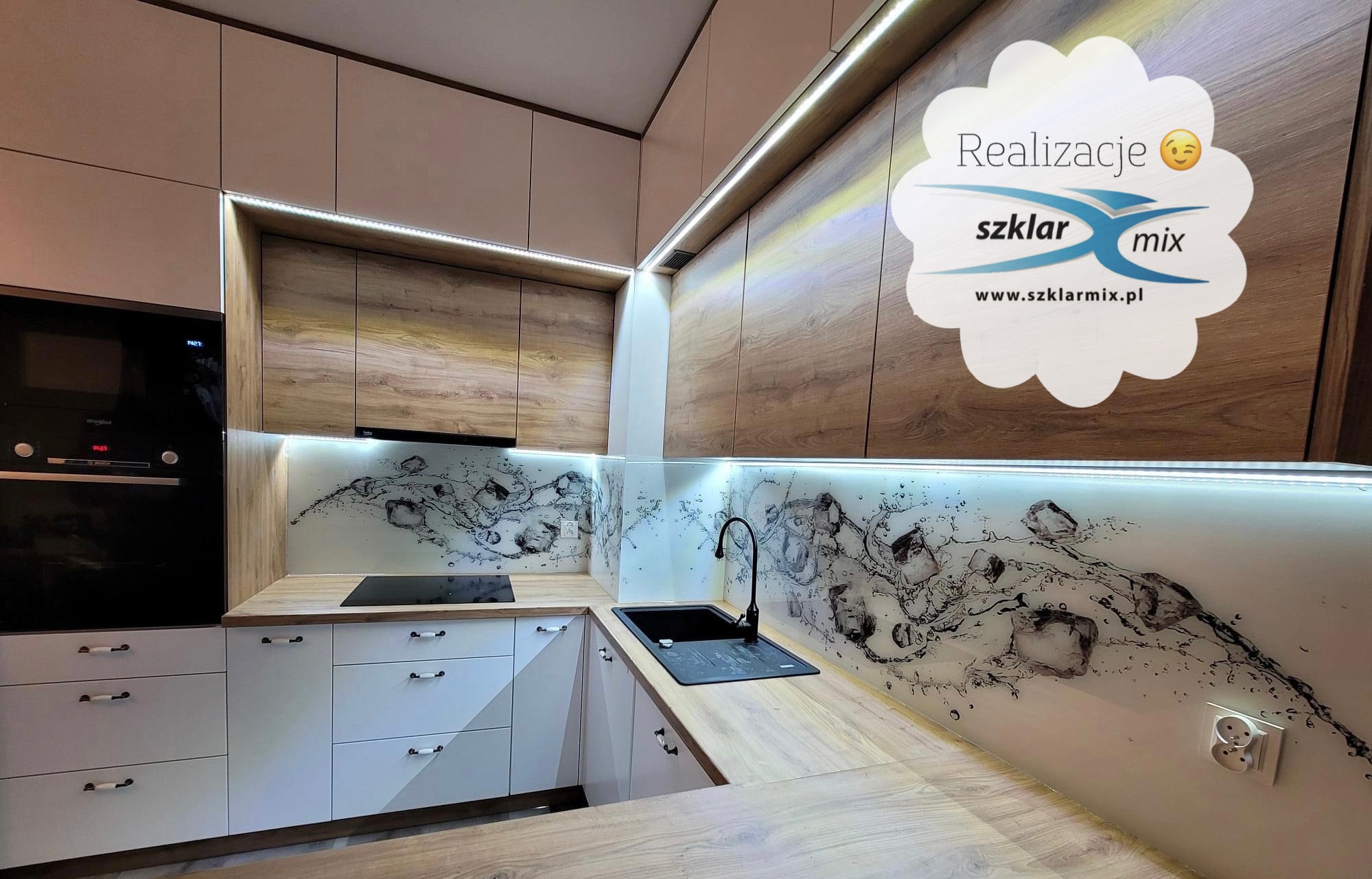 Kuchnia z panelami szklanymi z motywem kostek lodu i wody, podświetlane LED, białe szafki z drewnianymi blatami, czarny zlew i płyta indukcyjna, naklejka z napisem 'Realizacje szklar mix www.