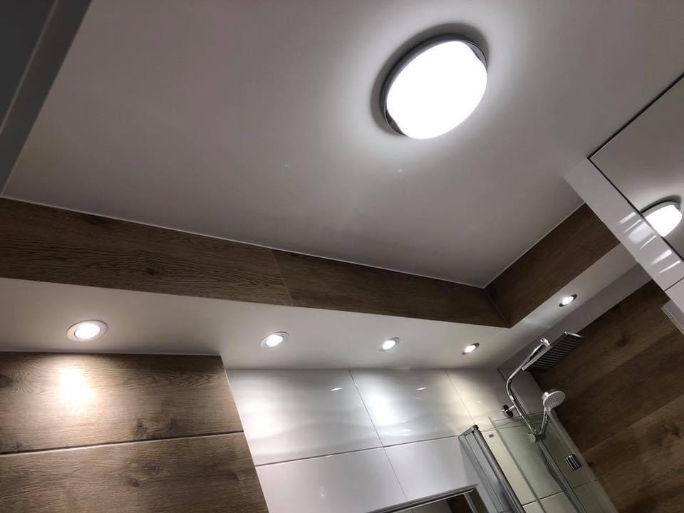 Wykończona łazienka w Gdańsku z drewnopodobnymi panelami na ścianach i suficie, oświetleniem punktowym i kabiną prysznicową z deszczownicą.