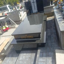 K2 STONE Kamieniarstwo Chruślicki - Czarny, nowoczesny nagrobek z wygrawerowanym napisem 'Stefania Szabla' na cmentarzu, otoczony szarą kostką brukową i innymi nagrobkami. Słoneczny dzień.