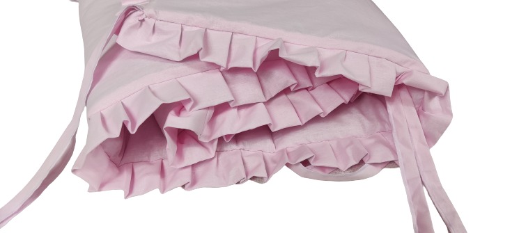 Jasnoróżowy baldachim do łóżeczka dziecięcego z falbanami i wiązaniami, widok z dołu.