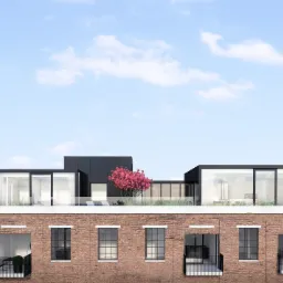 Wizualizacja budynku z czerwonej cegły z nowoczesną nadbudową z dużymi oknami i tarasem na dachu, gdzie rośnie drzewo z różowymi kwiatami.