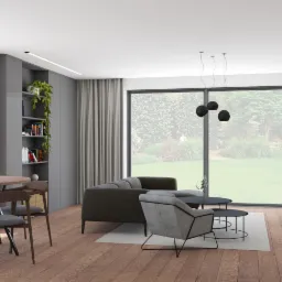 Jasny salon w domu jednorodzinnym z drewnianą podłogą, szarą sofą, okrągłym stołem z krzesłami, telewizorem na ścianie z białymi szafkami i dużymi oknami z widokiem na ogród.