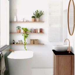 Jasna łazienka w minimalistycznym stylu z wolnostojącą wanną, umywalką nablatową na drewnianej szafce z czarnym blatem oraz półkami z roślinami i akcesoriami.