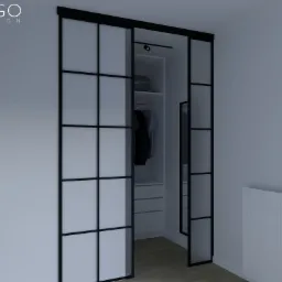 Nowoczesna garderoba z przesuwnymi drzwiami w stylu loft z czarnymi szprosami, oświetlona punktowo, z widoczną zawartością szafy: ubrania na wieszakach i walizka na półce.