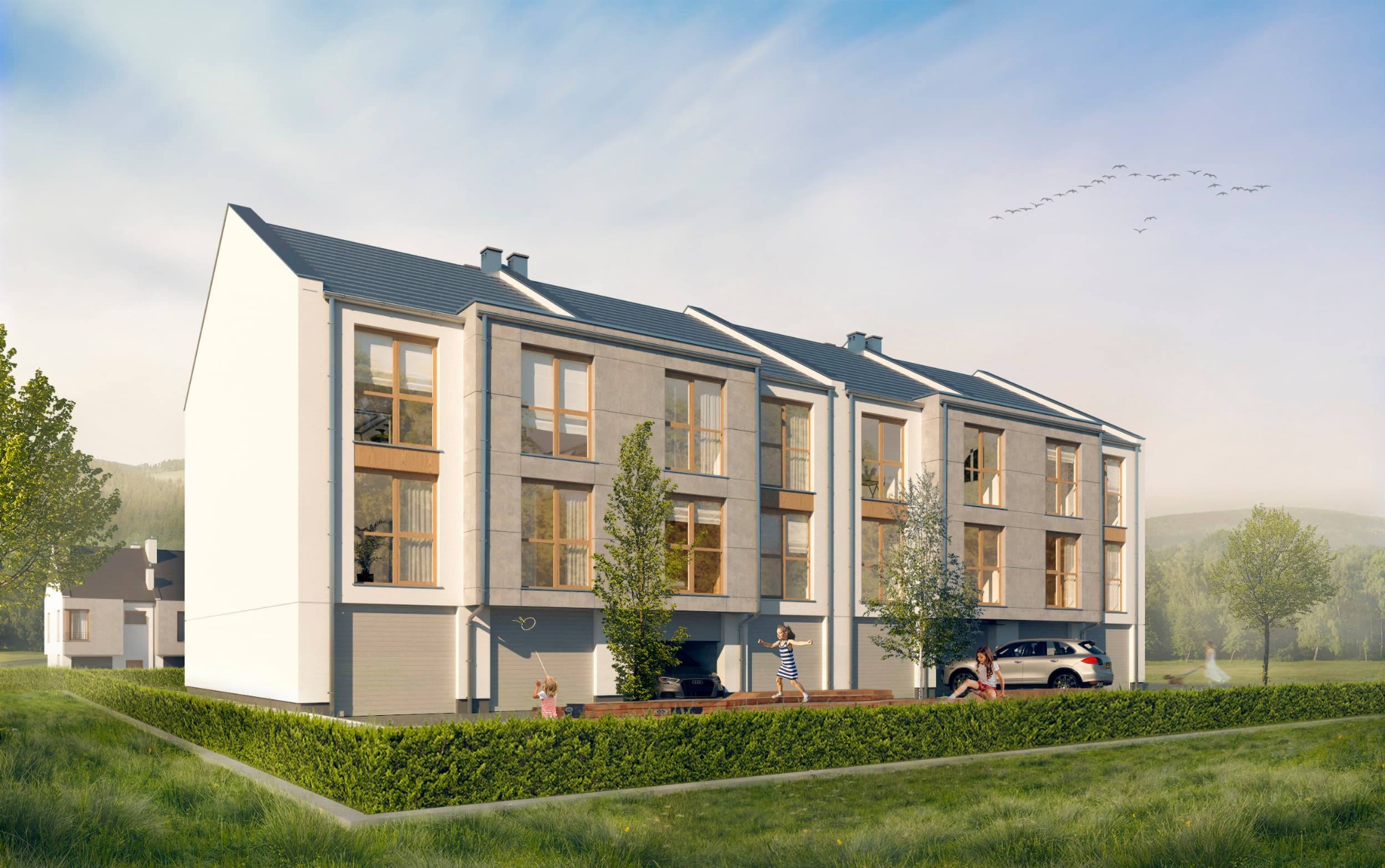 Wizualizacja szeregu nowoczesnych domów z garażami, w tle krajobraz z zielonymi wzgórzami i kluczem ptaków na niebie, dzieci bawiące się na podjeździe, samochód zaparkowany przed jednym z domów.