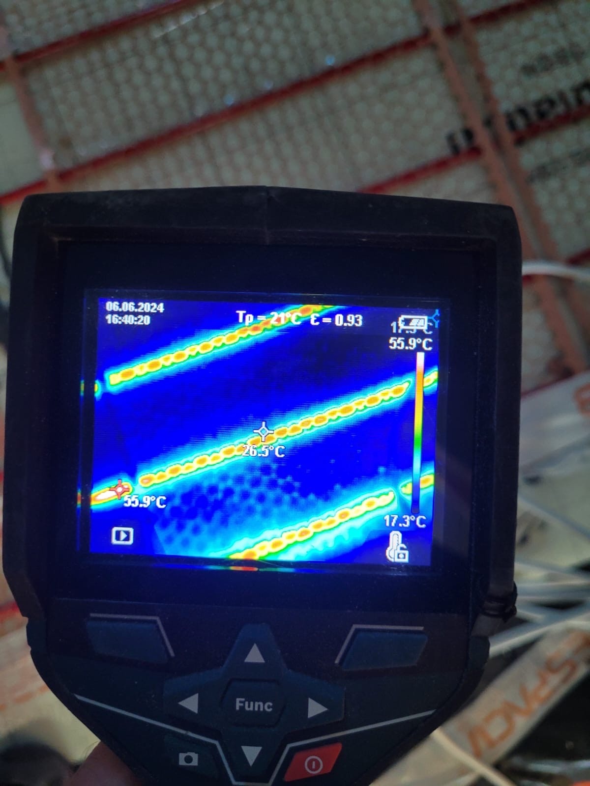Termowizja maty grzewczej pod panelami, wskazująca temperaturę 55.9 stopni Celsjusza w najcieplejszym miejscu, widziana na ekranie kamery termowizyjnej z datą 06.06.2024.