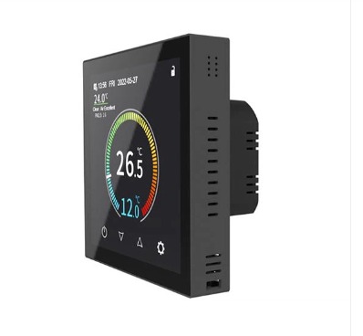 Dotykowy regulator temperatury pokojowej z wyświetlaczem LCD, ustawiony na 26.5 stopni Celsjusza, zamontowany na ścianie, widoczne otwory wentylacyjne po prawej stronie obudowy.