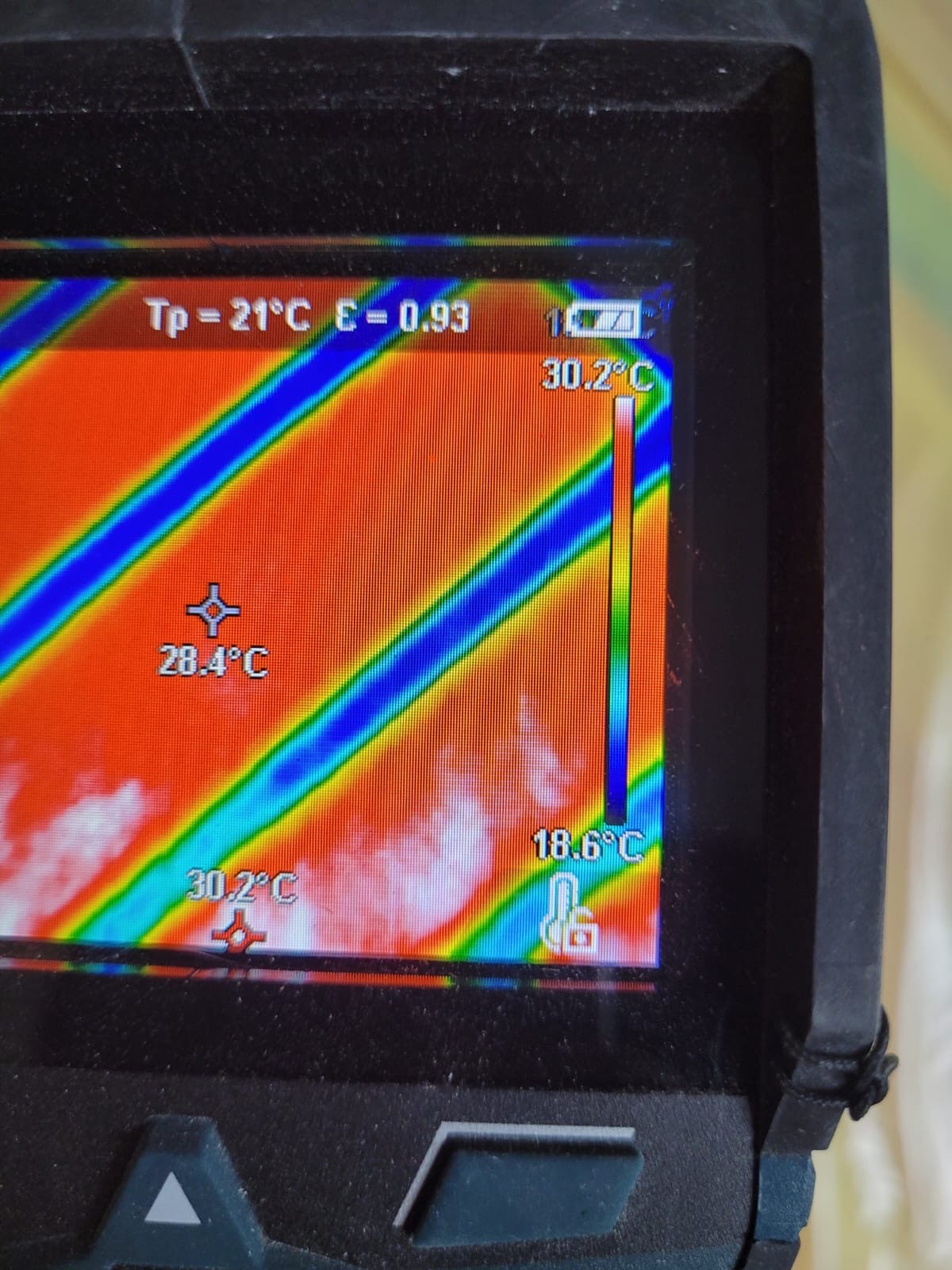 Ekran kamery termowizyjnej z widocznym rozkładem temperatur na powierzchni, wskazujący na potencjalne nierównomierne ogrzewanie lub straty ciepła, z zaznaczonymi punktami pomiarowymi 28.4°C i 30.