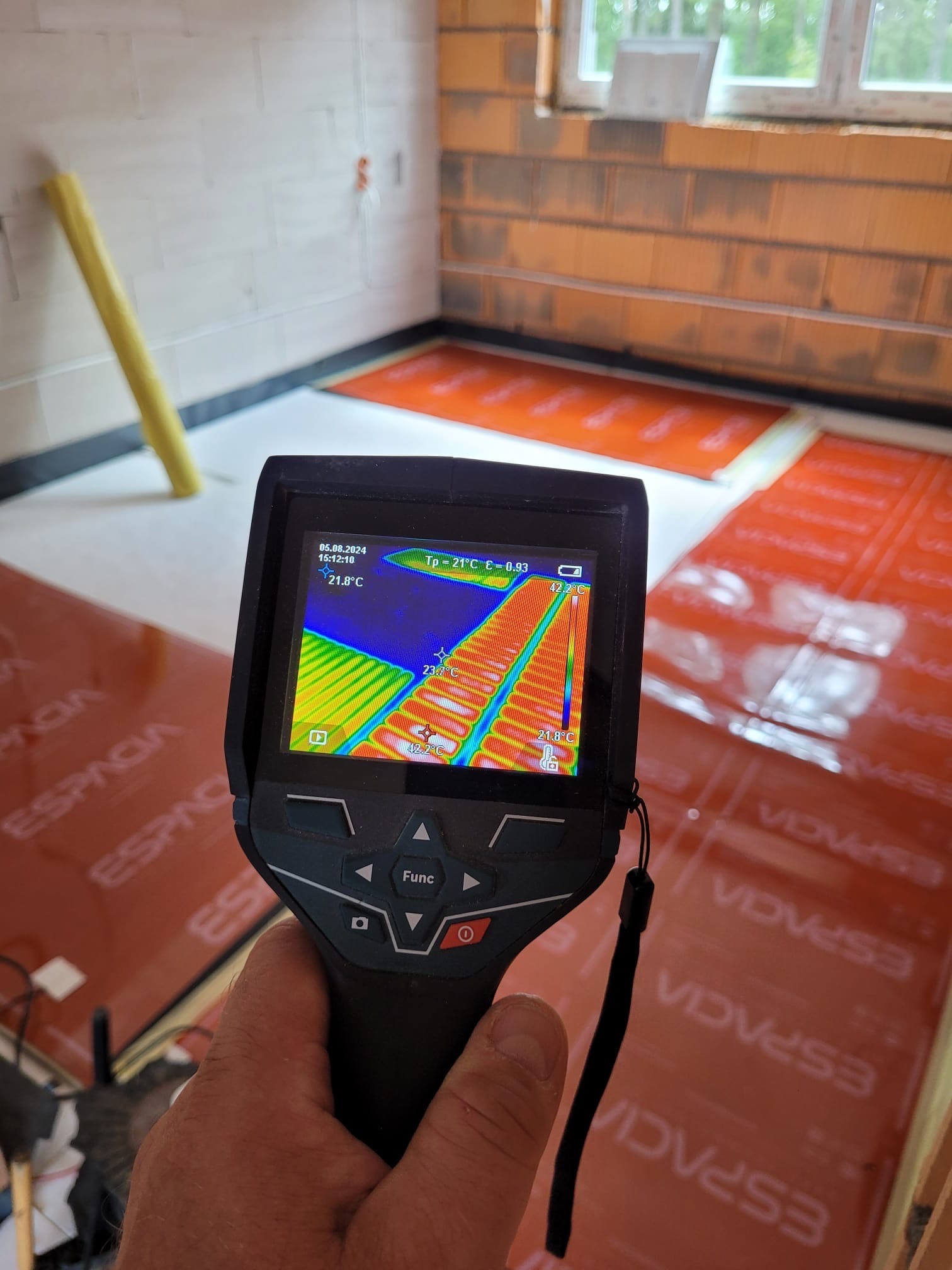 Termowizja maty grzewczej na podłodze w trakcie instalacji, widok z kamery termowizyjnej pokazującej rozkład temperatur.