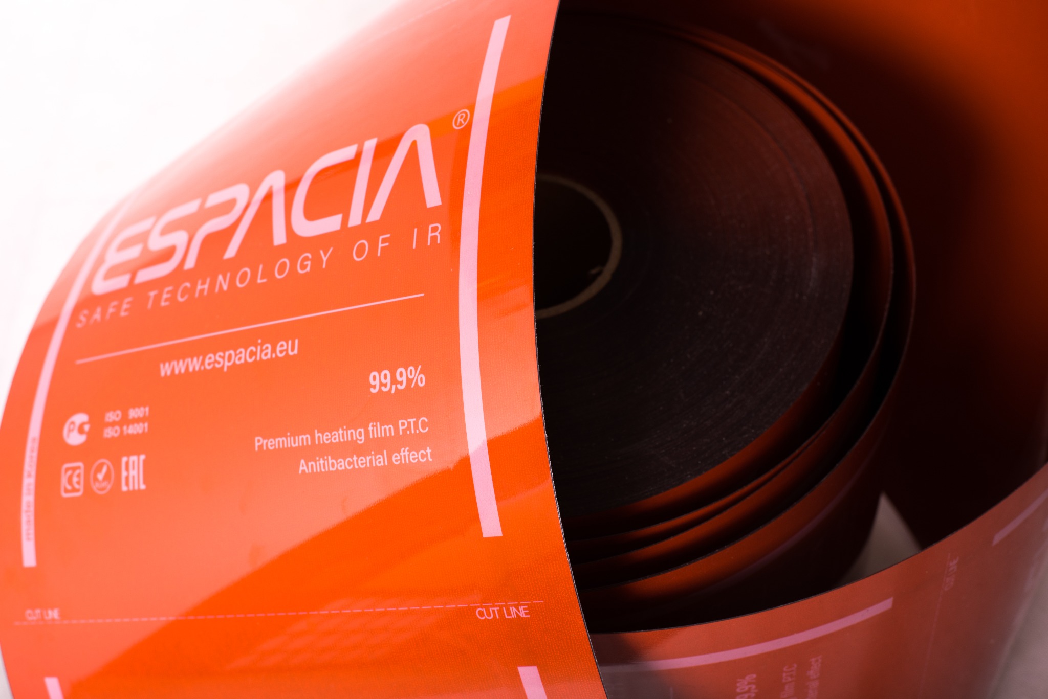 Rolka maty grzewczej marki Espacia w pomarańczowym opakowaniu z informacjami o produkcie, w tym logo, adres strony internetowej i certyfikaty jakości.