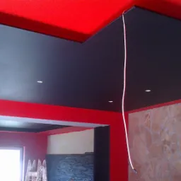 Czerwono-czarne malowanie sufitu i ścian w Skarżysko-Kamiennej, z widocznym oświetleniem punktowym i fragmentem ściany z kamienia dekoracyjnego.