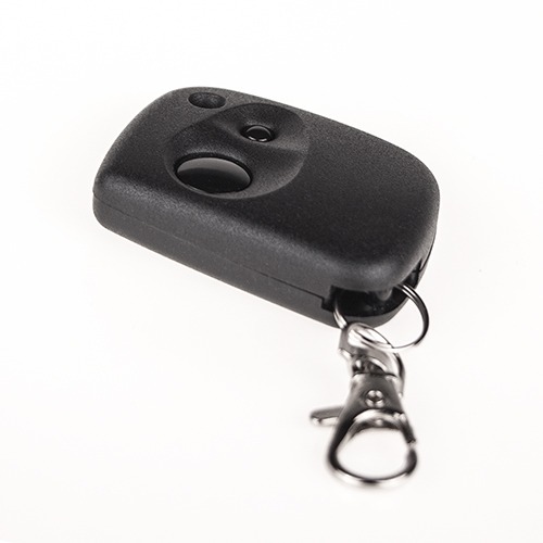 Czarny pilot do bramy z metalowym kółkiem i karabińczykiem na białym tle, widoczne dwa przyciski i otwór na diodę.