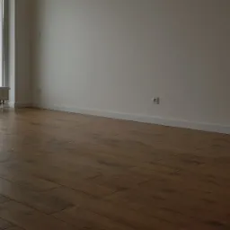 Ułożone panele podłogowe w odcieniach brązu w pustym pokoju z grzejnikiem pod oknem i białymi ścianami.