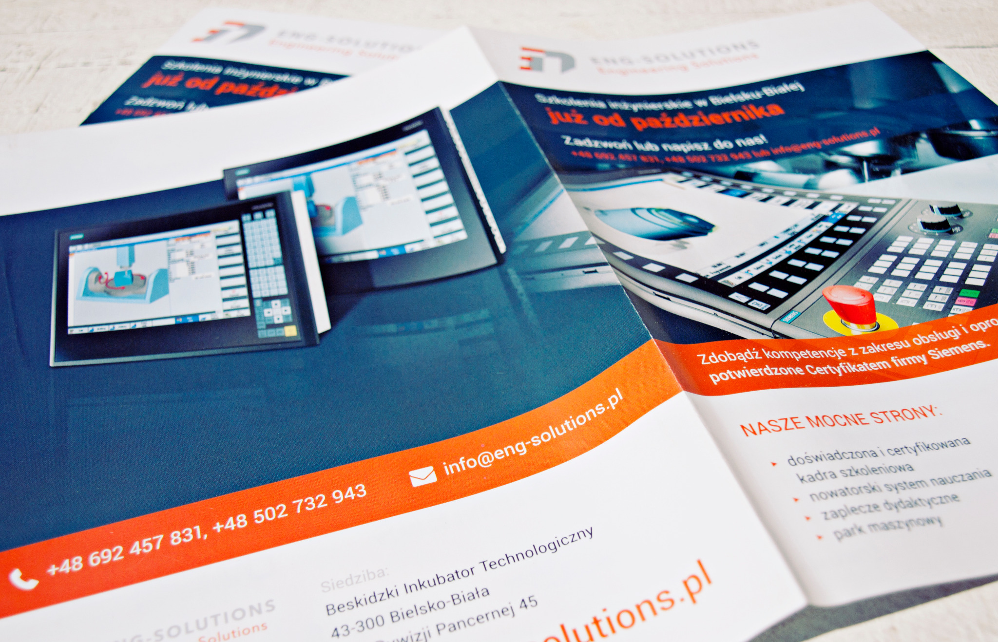 Rozłożona ulotka reklamowa firmy ENG Solutions prezentująca szkolenia inżynierskie, z bliska widoczne ekrany z interfejsem CAD/CAM oraz panel sterowania maszyn CNC.