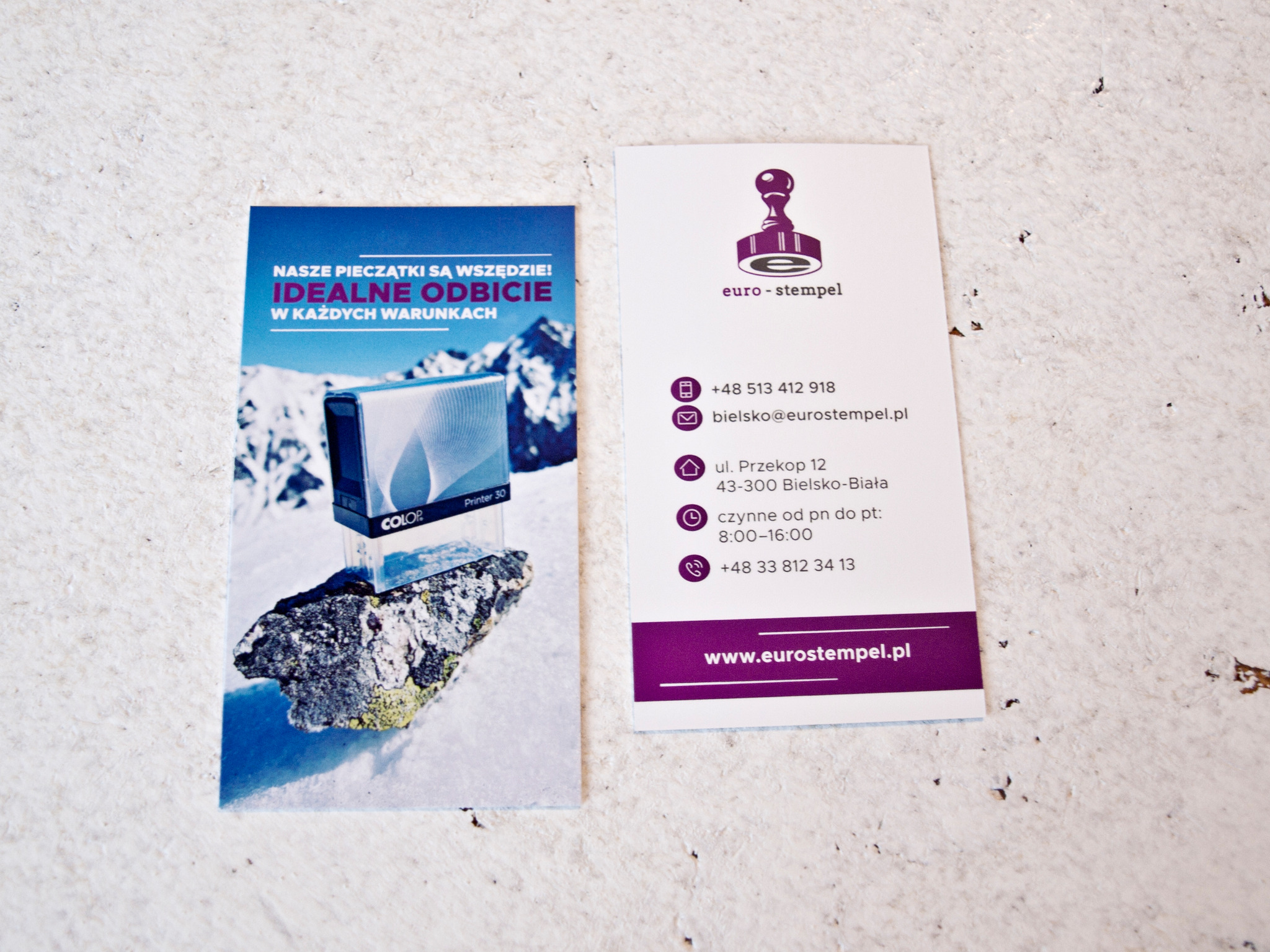 Dwie karty: po lewej ulotka z hasłem 'Nasze pieczątki są wszędzie! Idealne odbicie w każdych warunkach' i zdjęciem pieczątki na tle górskiego krajobrazu, po prawej wizytówka firmy euro-stempel...
