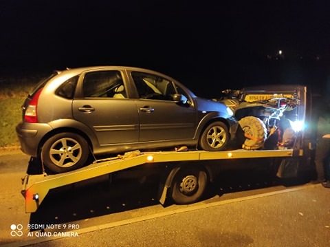 Laweta z szarym Citroenem C3 i quadem w nocy, oświetlona światłami lawety.