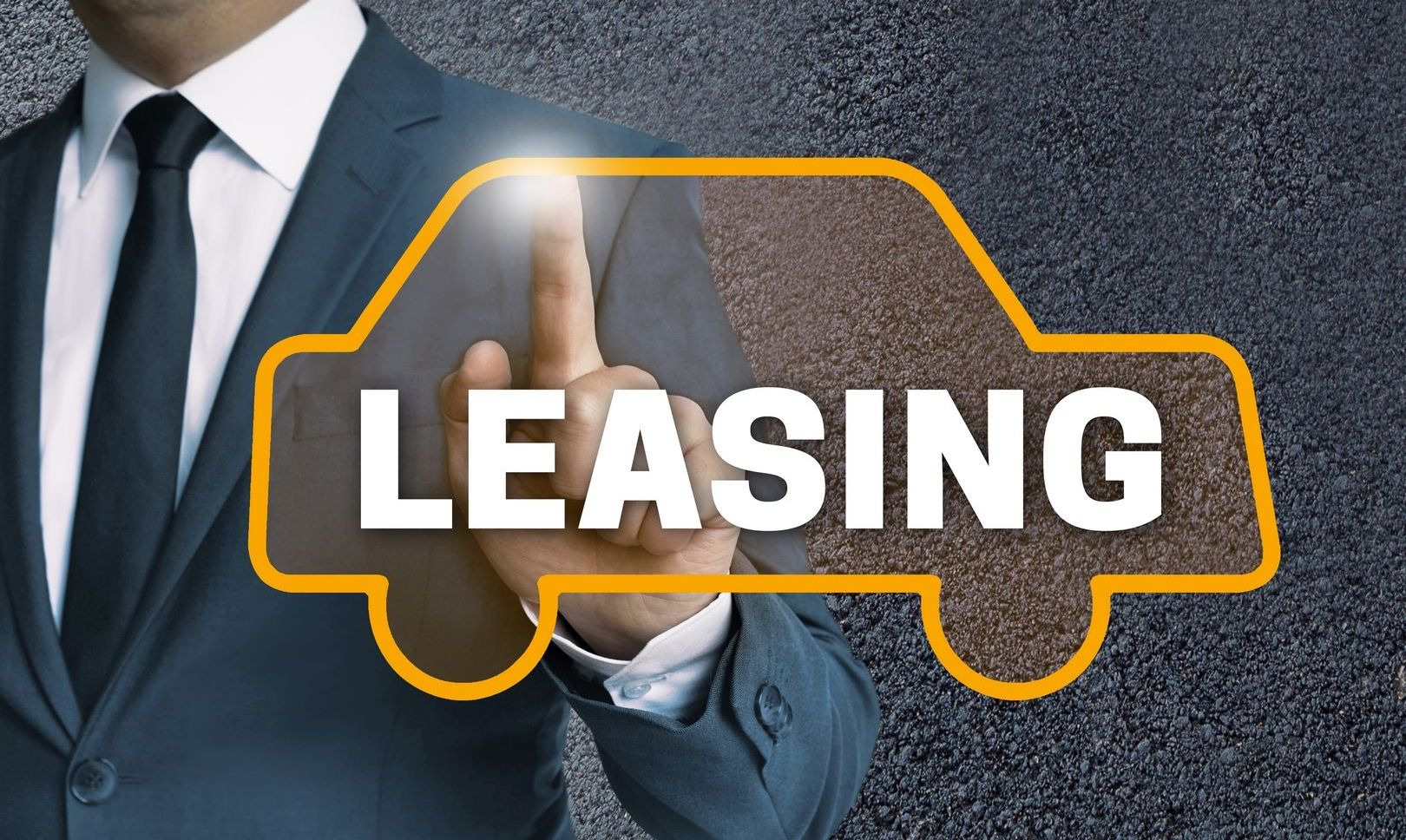 Mężczyzna w garniturze dotyka palcem wirtualnego samochodu z napisem LEASING na tle asfaltu.